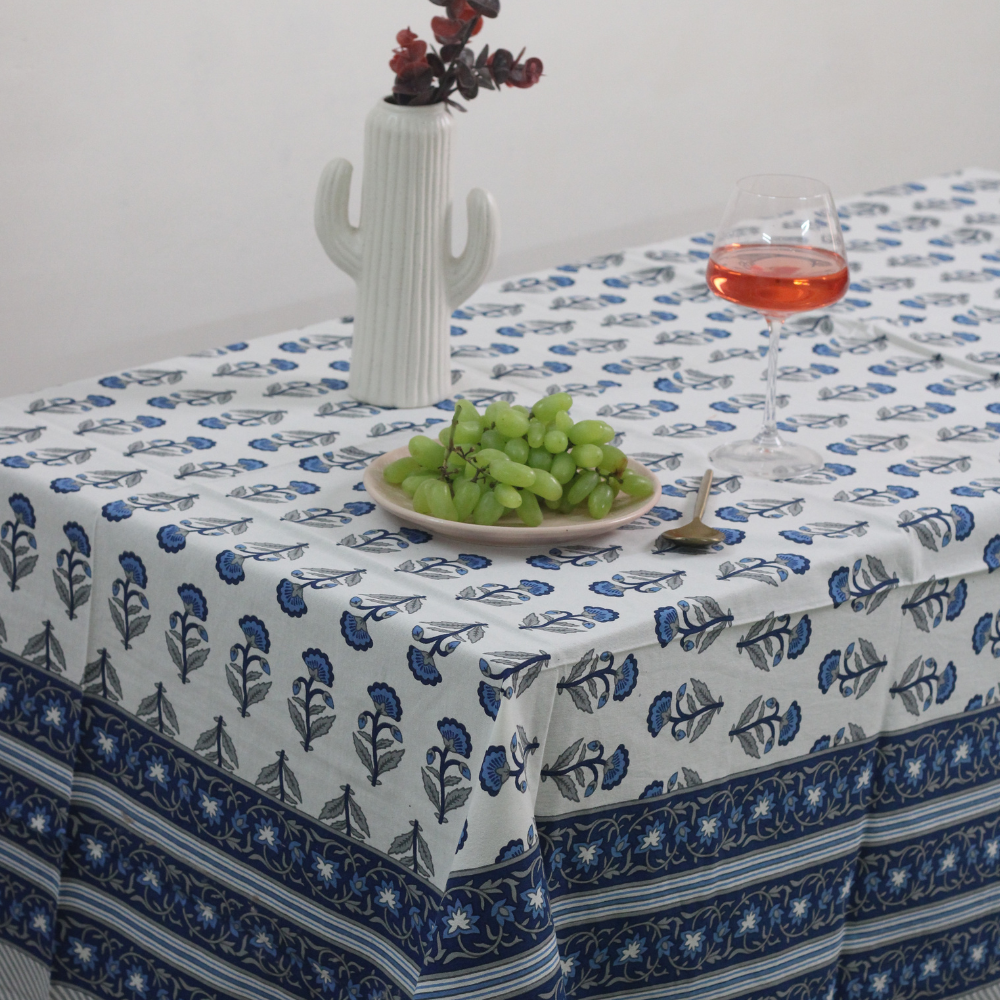 Blue motif table cloth on table with fruits & juice on it