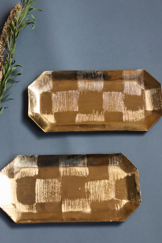 Two square patterned gold platters
