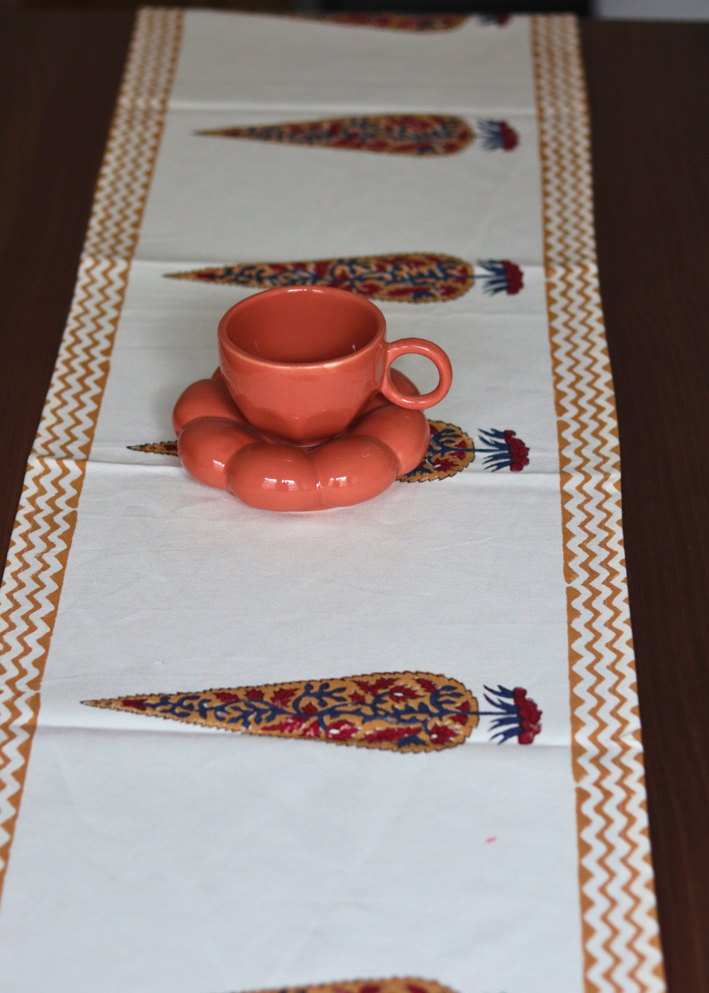 Cherry blossom table runner with cup & saucer on it