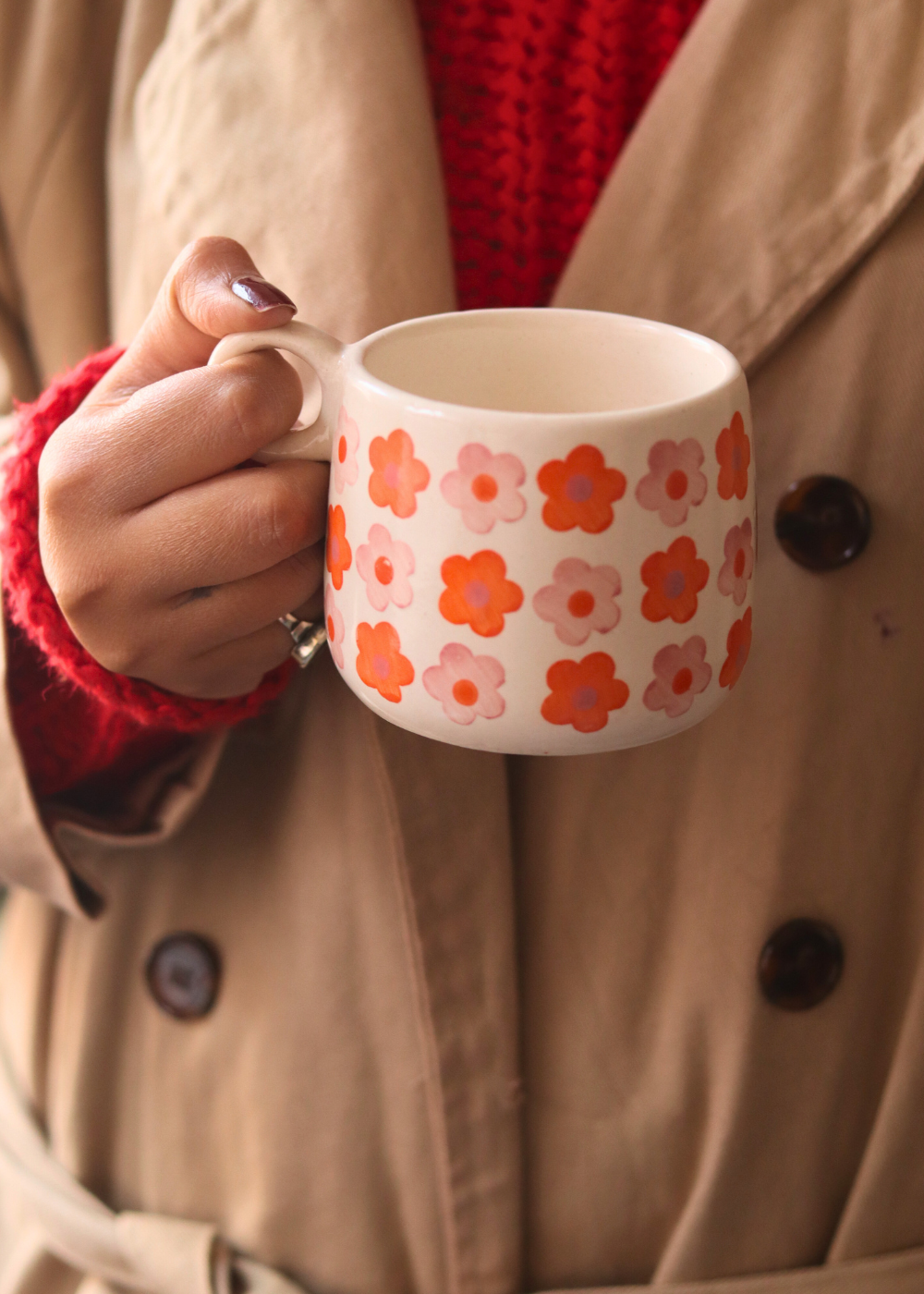 Handmade ceramic coffee mug in hand 