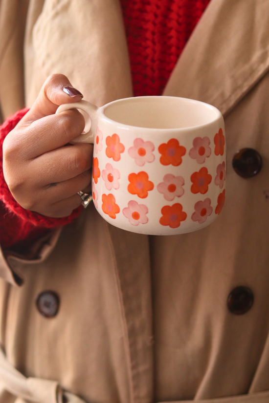 Handmade ceramic coffee mug in hand 