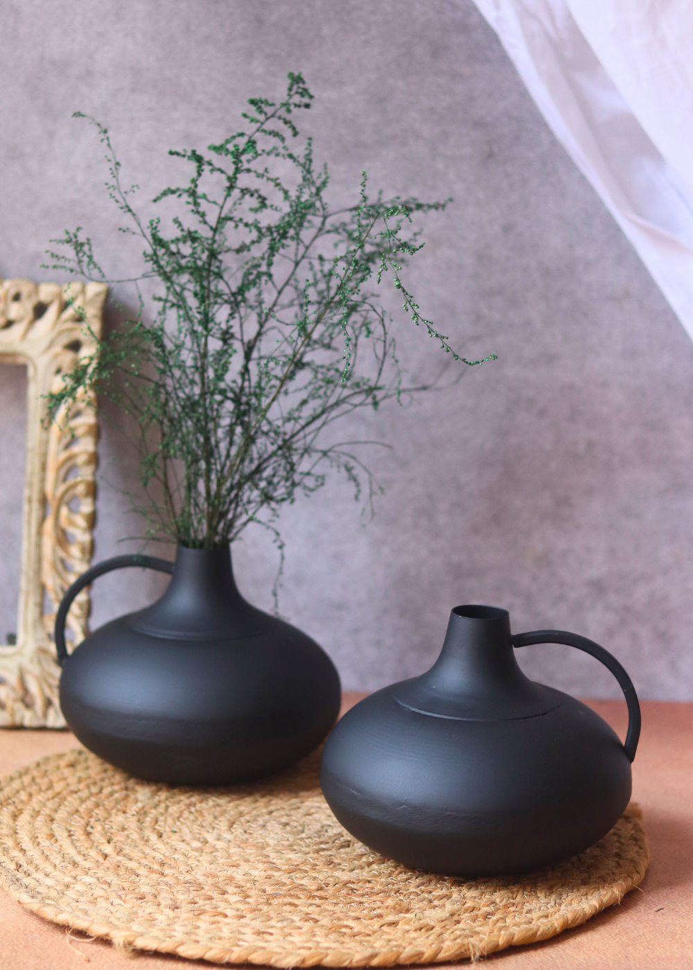 Two black handmade flower pots with plant