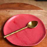 handmade red snacks plate with golden spoon