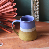 Blue & Mustard coffee mug on wooden surface