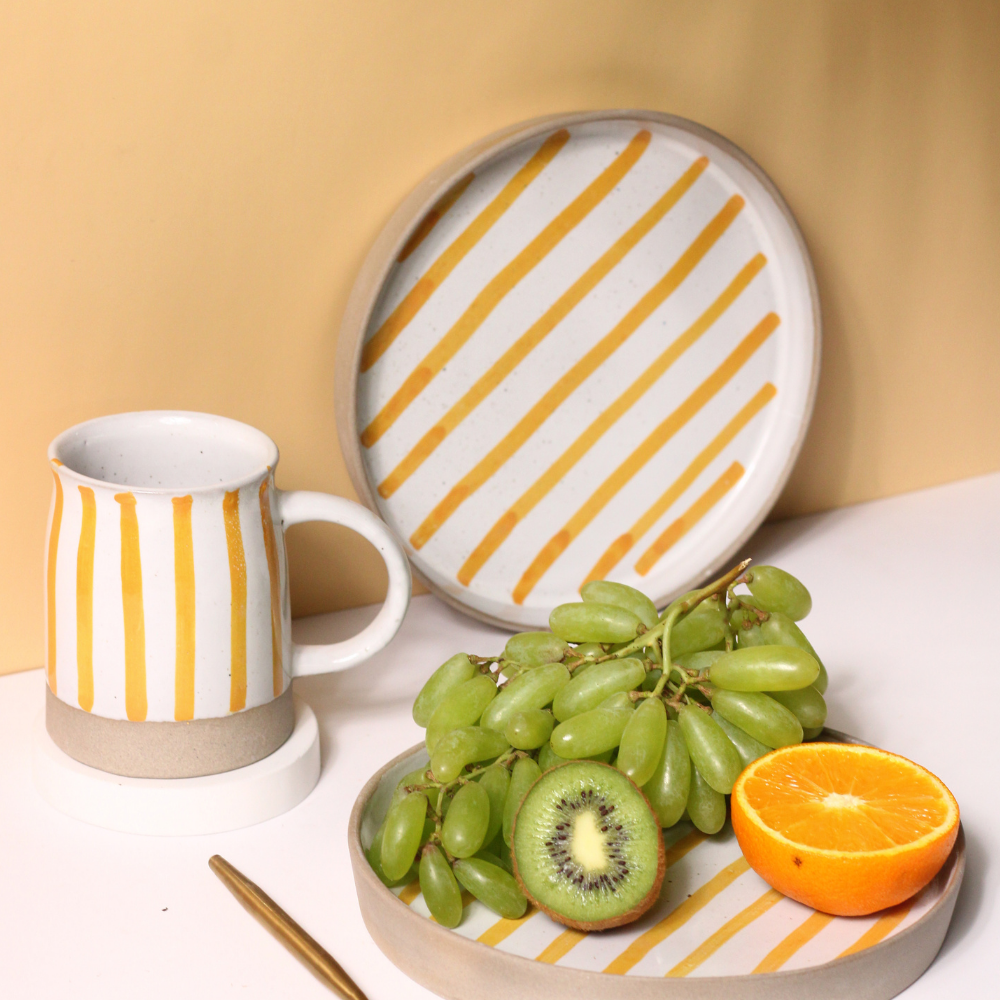 handmade yellow striped mug & platter with fruits & golden spoon