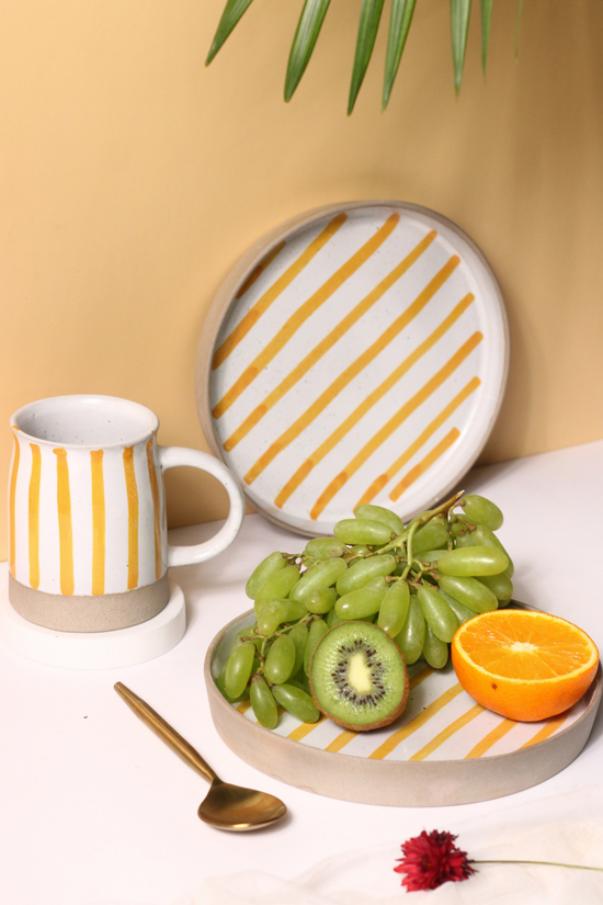 handmade yellow striped mug & platter with fruits & golden spoon