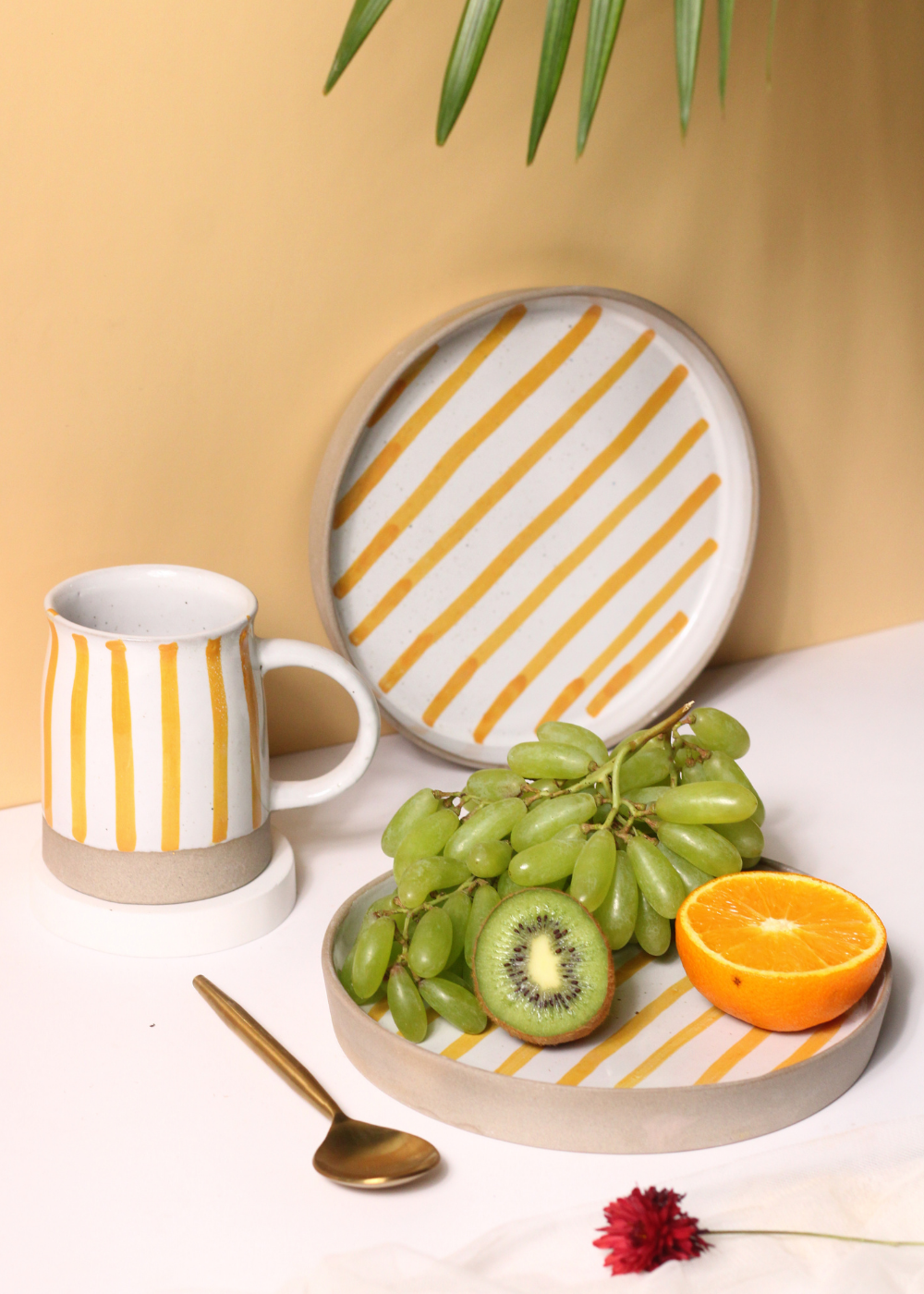 handmade yellow striped mug & platter with fruits & golden spoon