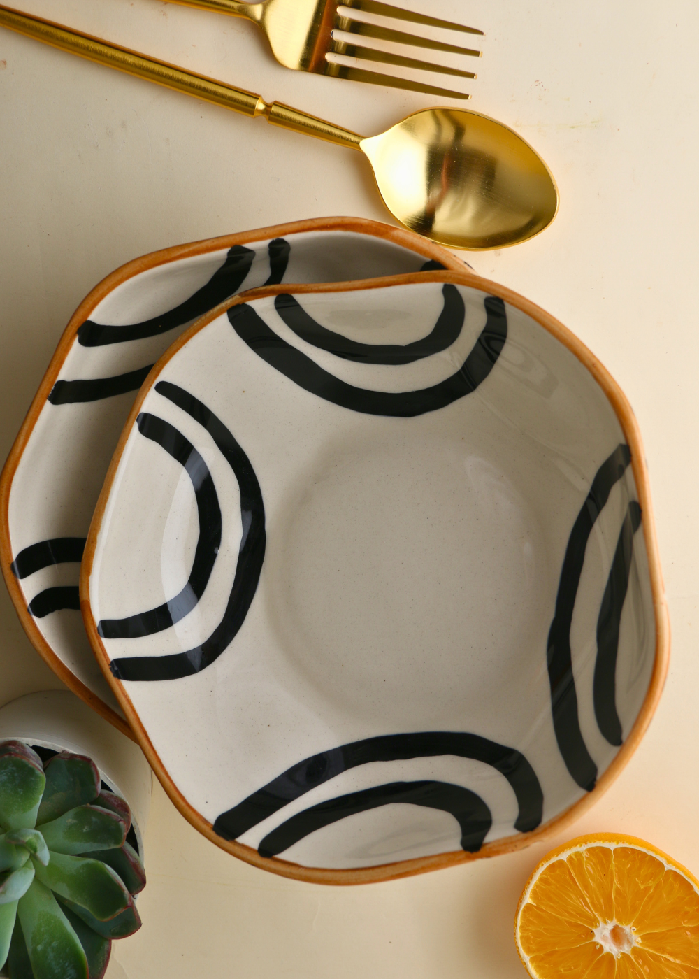  Two black and white bowl with cutleries and orange