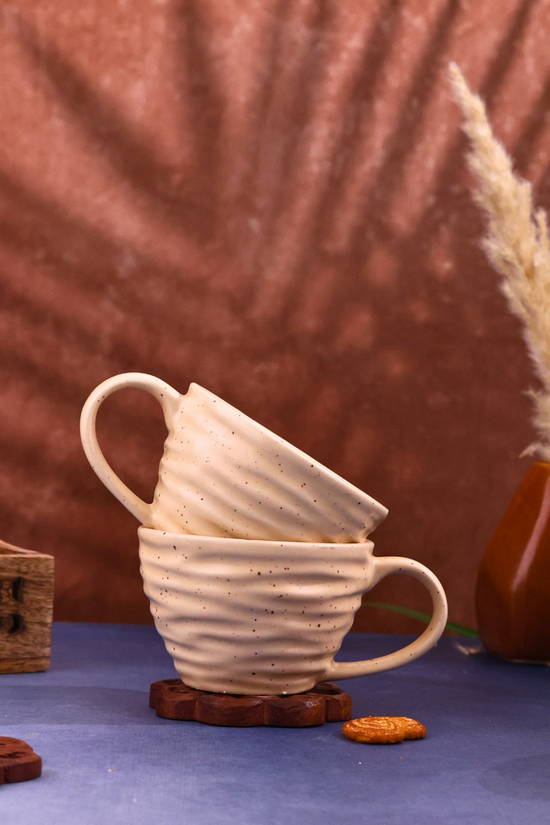 Two twirl coffee mugs on wooden surface