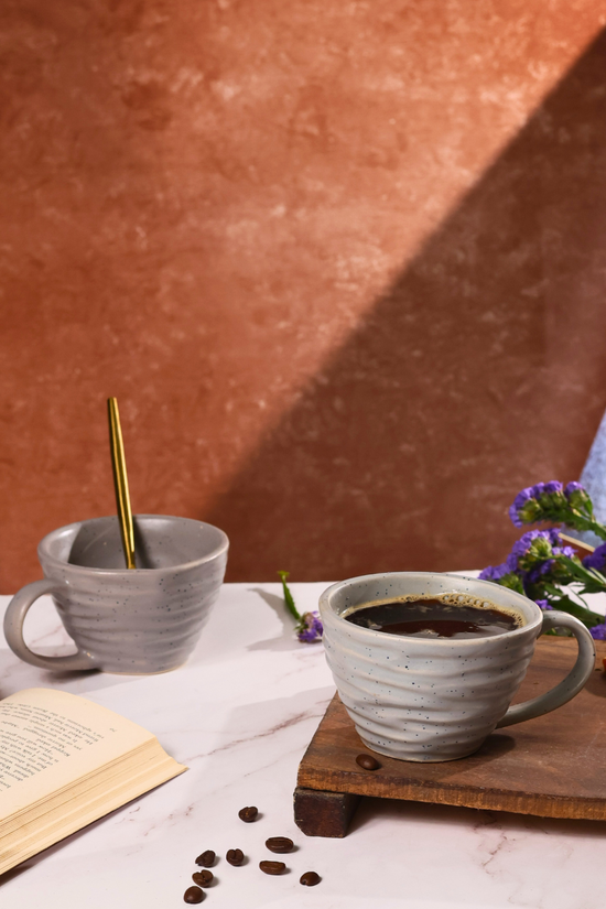 Grey mug with twirl design with tea