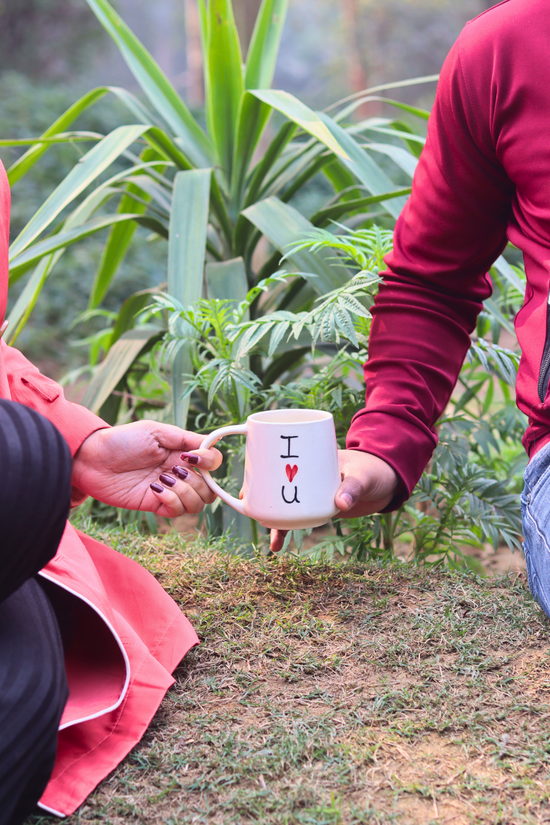 A couple holding a coffee mug quoted i heart you