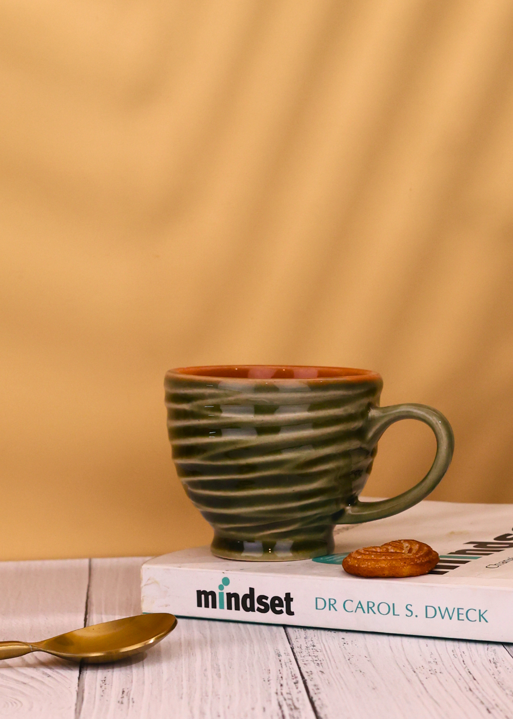 Green torrent chai cup on book