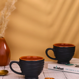 Two tea cups black colored with book