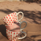 red patterned mugs made by ceramic 