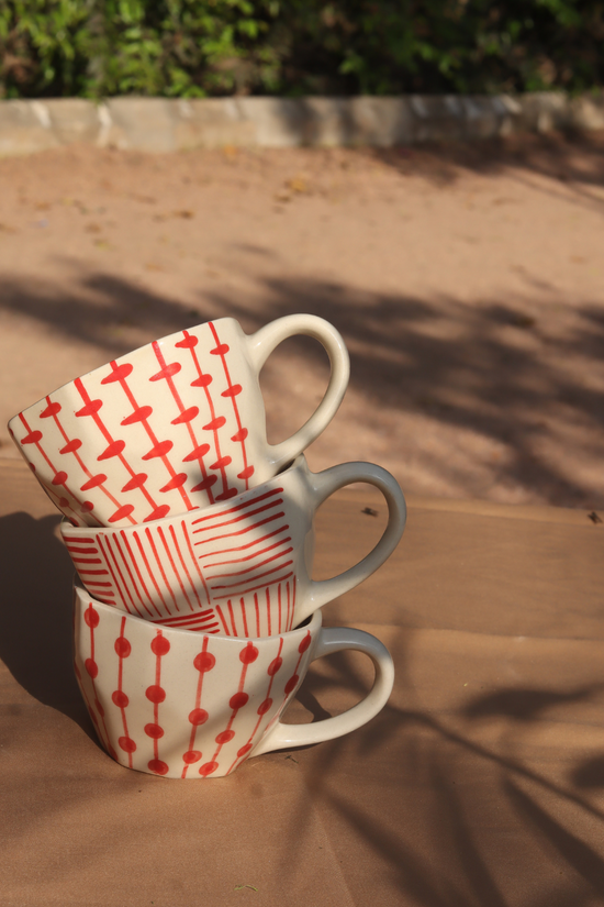 red patterned mugs made by ceramic 