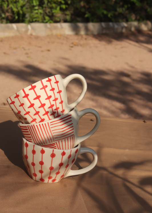 red patterned mugs made by ceramic 