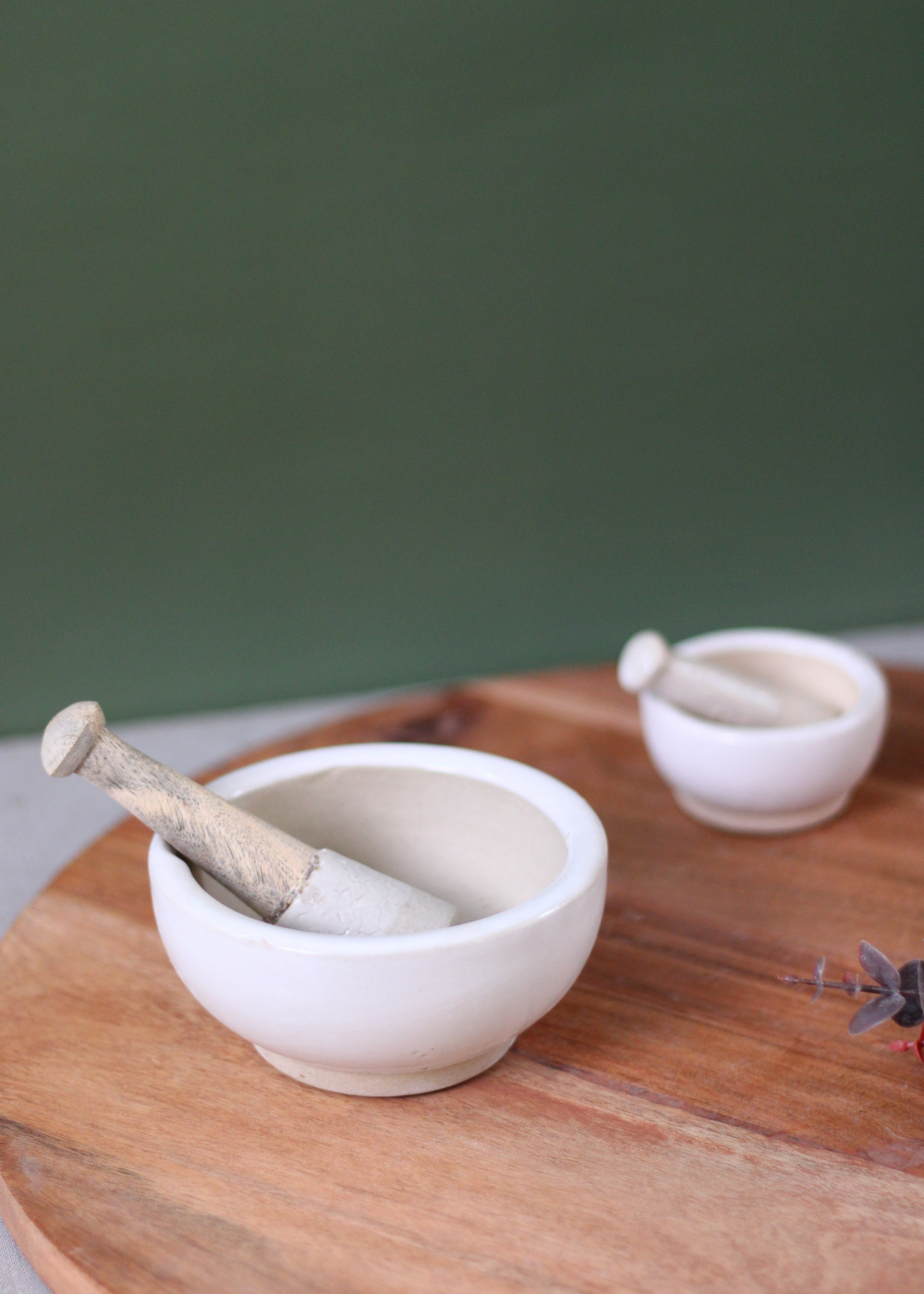 Two marble mortar & pestles on wooden surface