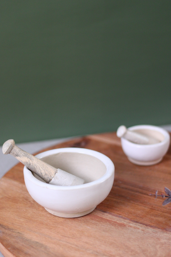 Two marble mortar & pestles on wooden surface