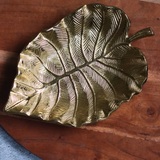 Handmade golden palm leaf bowl on wood