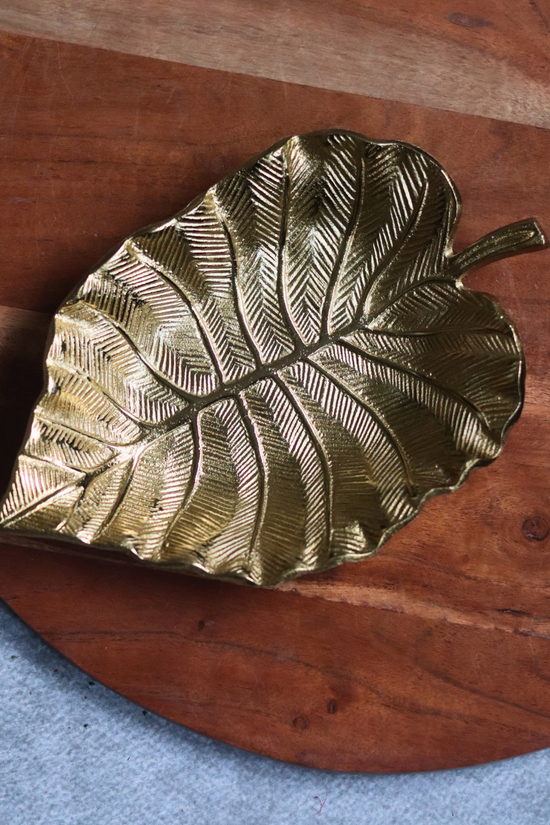 Handmade golden palm leaf bowl on wood