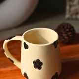 Handmade black & white mug with black flower design on it