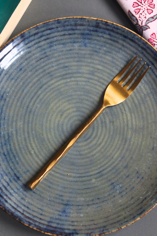 Handmade gold hammered fork on plate