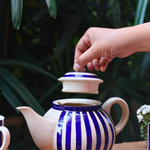 Tea pot with blue stripes on it