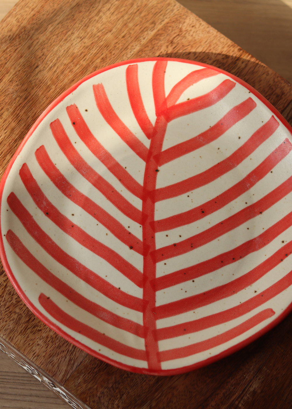 Red leaf plate on wooden surface 