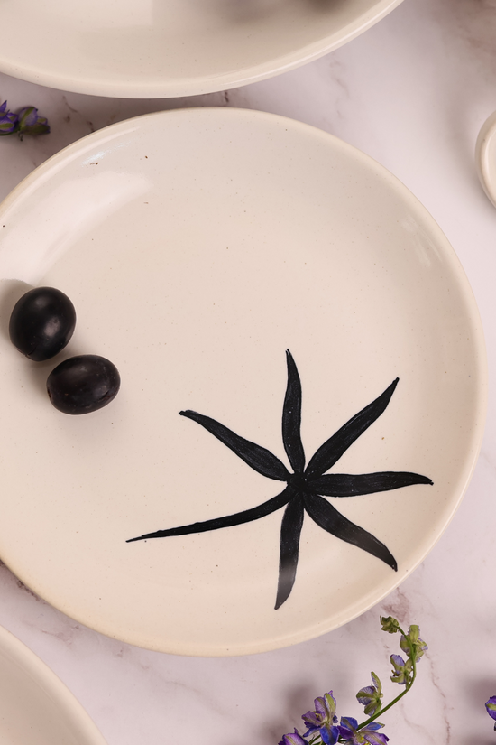 White plate with black leaf print on it