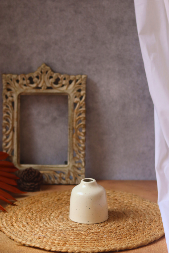 Cream bud vase on mat