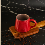Hot red coffee mug on wooden surface