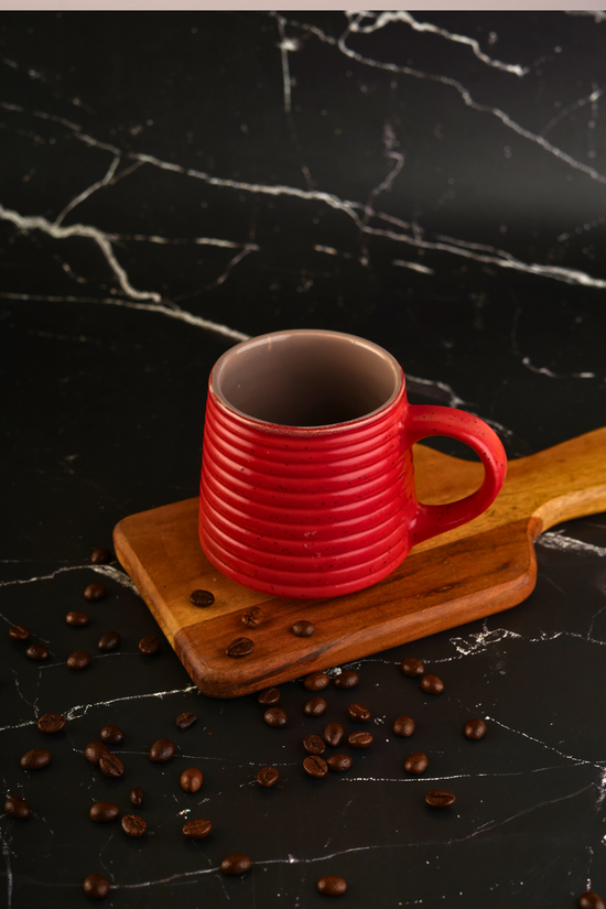 Hot red coffee mug on wooden surface