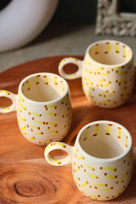 Three ceramic mugs on a wooden surface