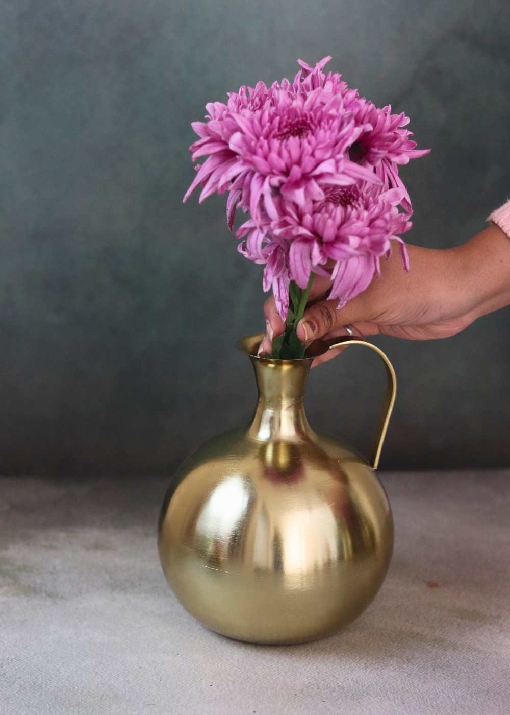 Brass mughal vase with flowers on hand