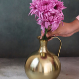 Brass mughal vase with flowers on hand