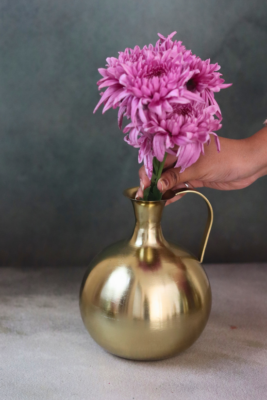Brass mughal vase with flowers on hand