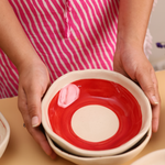 Red and white bowls in hand 