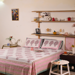 A systematic room with a block printed bedsheet on a bed