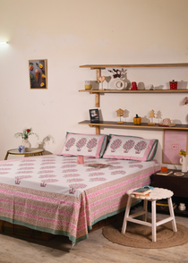 A systematic room with a block printed bedsheet on a bed
