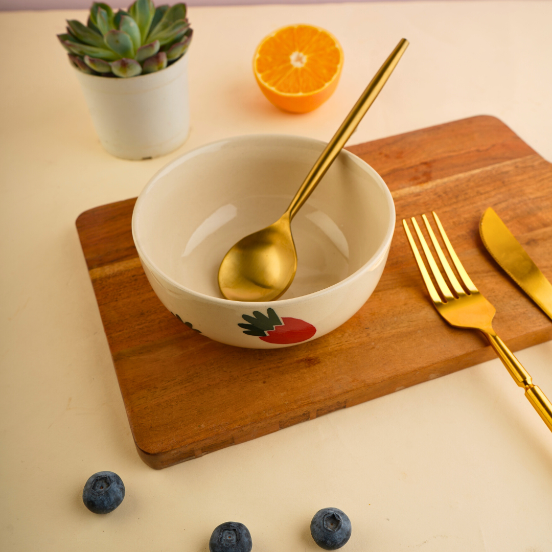 Strawberry bowl with spoon on a wooden surface