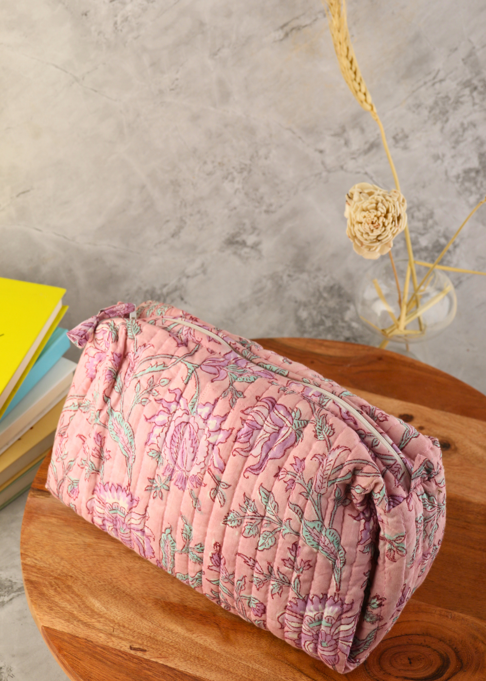 Pink floral toiletry bag on wooden surface