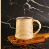 Handmade ceramic coffee mug with beans