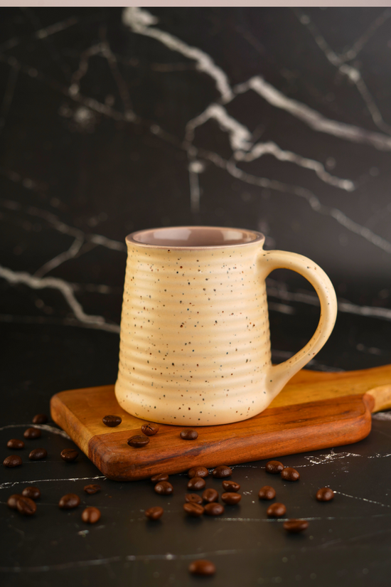 Handmade ceramic coffee mug with beans
