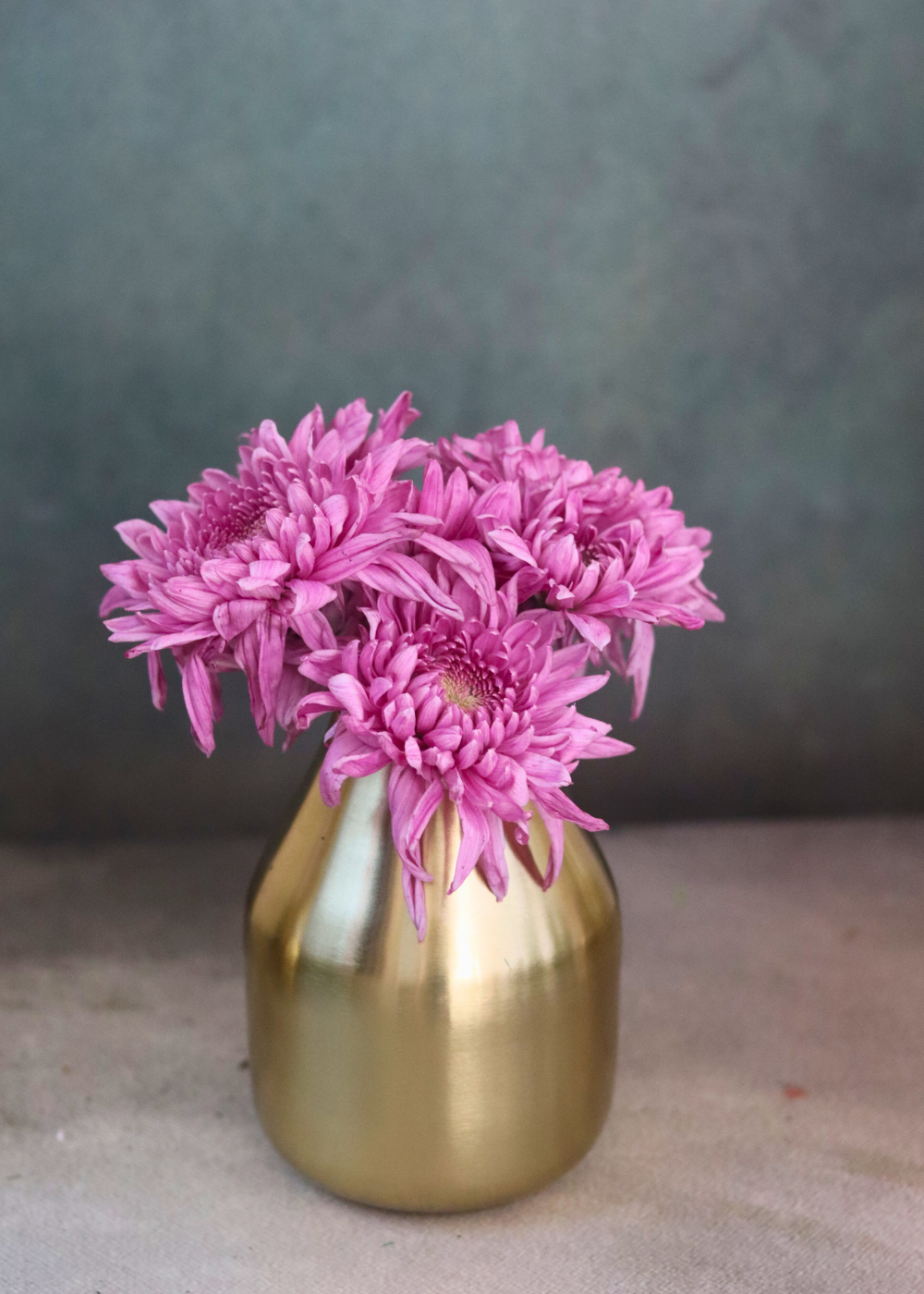 Brass glowing amber vase with pink flowers 