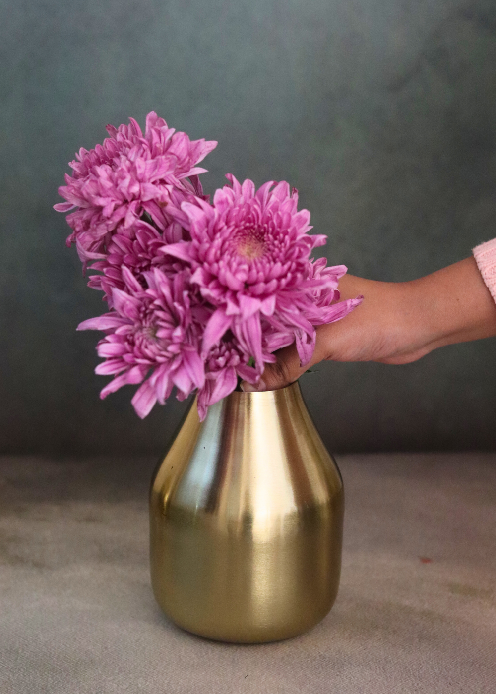 Brass glowing amber vase with flowers on hand