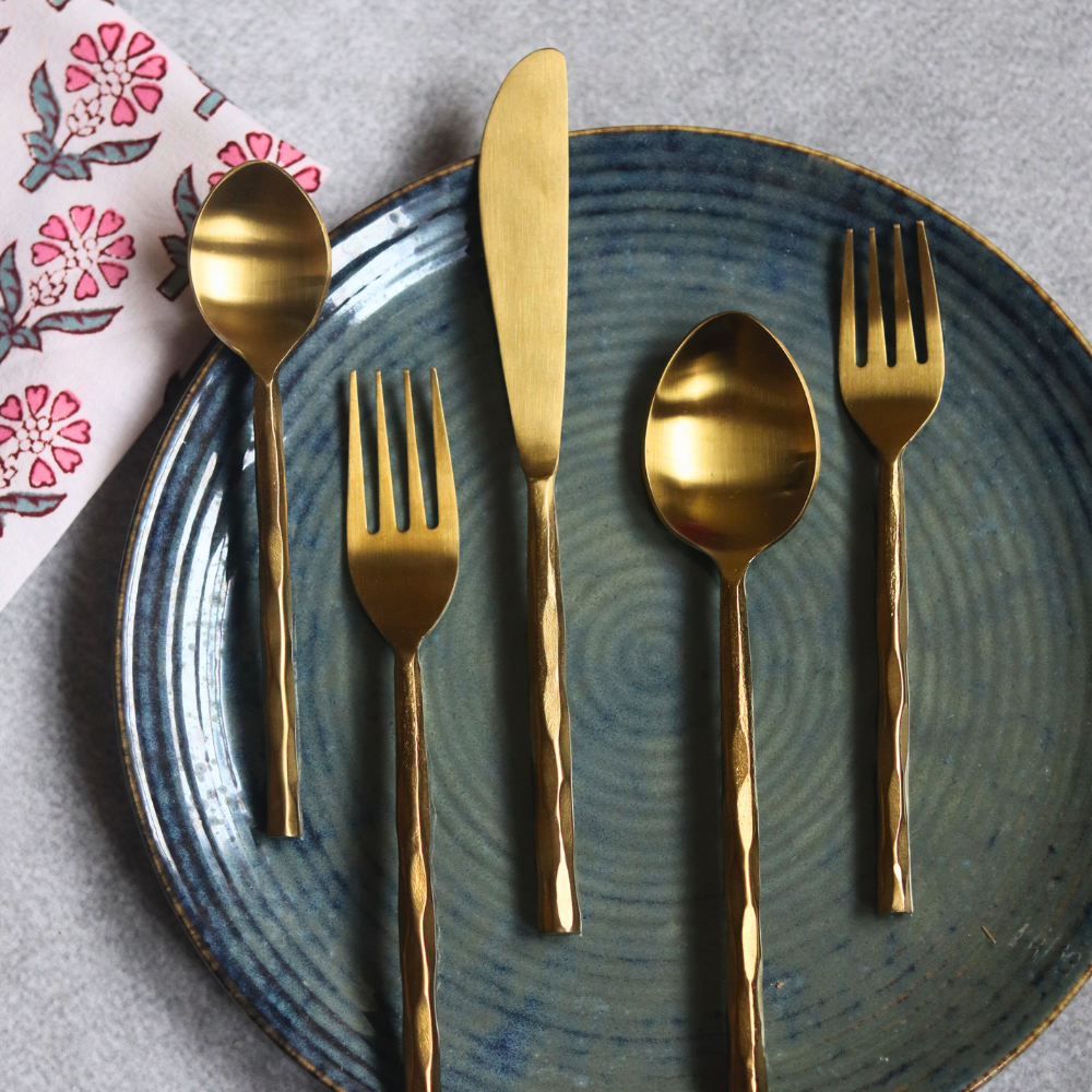 Handmade gold cutlery set on plate 