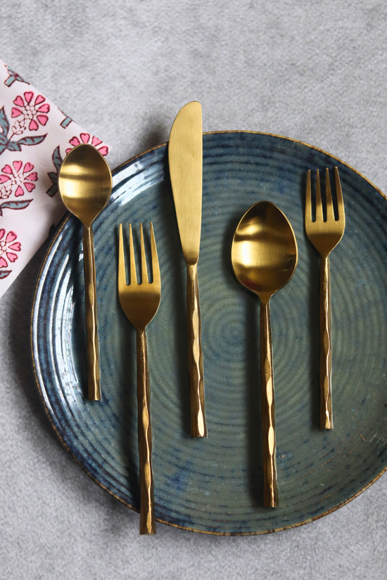 Handmade gold cutlery set on plate 