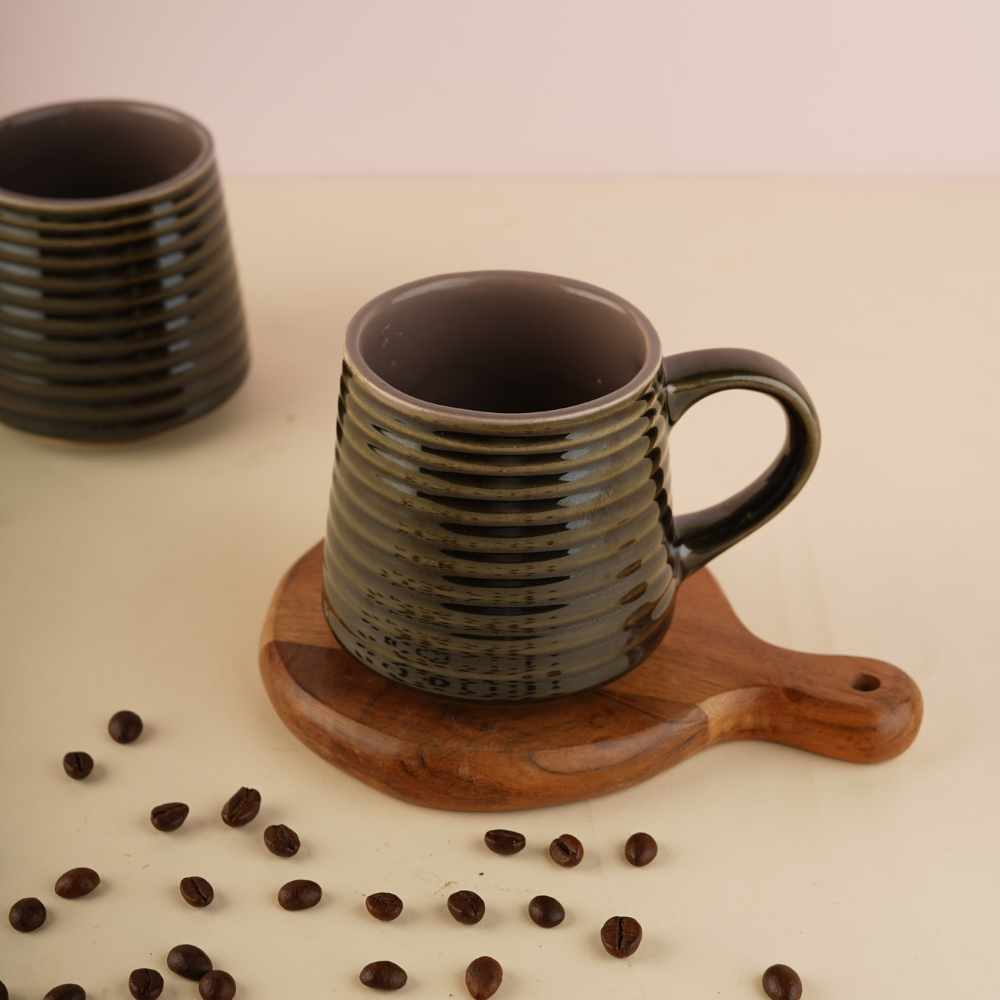 Glossy black coffee mug with beans