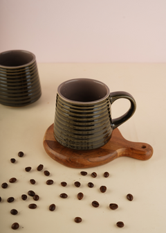 Glossy black coffee mug with beans