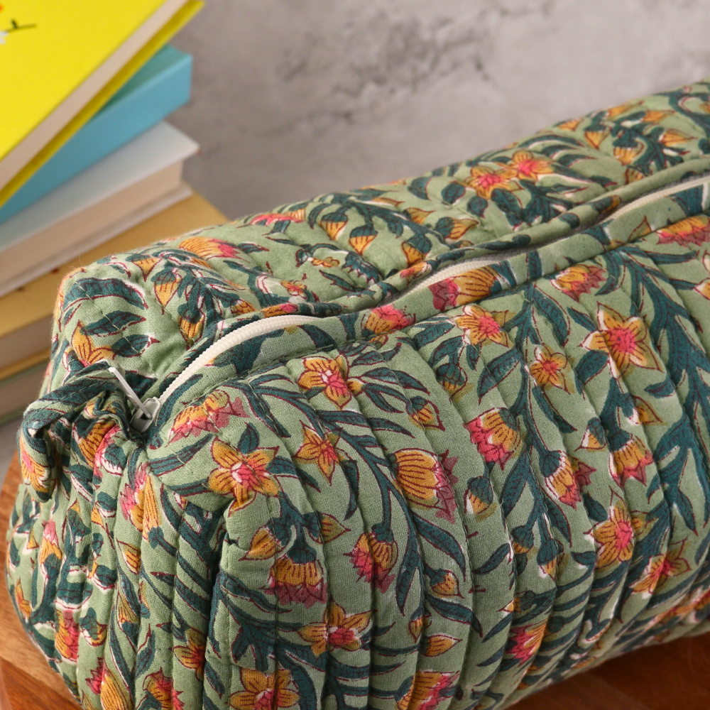 Block printed green toiletry bag on wooden surface